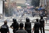 Demonstrators clash with police in Intilaka, outside Tunis.
