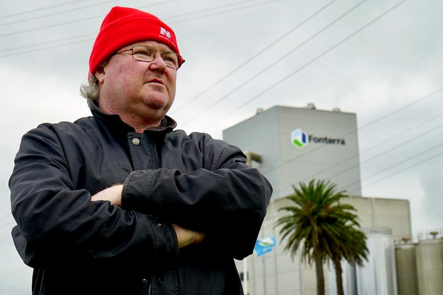 Damien Noonan stands outside a Fonterra building.