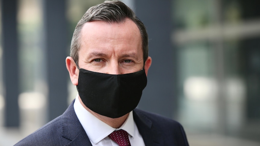 WA Premier Mark McGowan standing outside WA Parliament wearing a black COVID mask. 