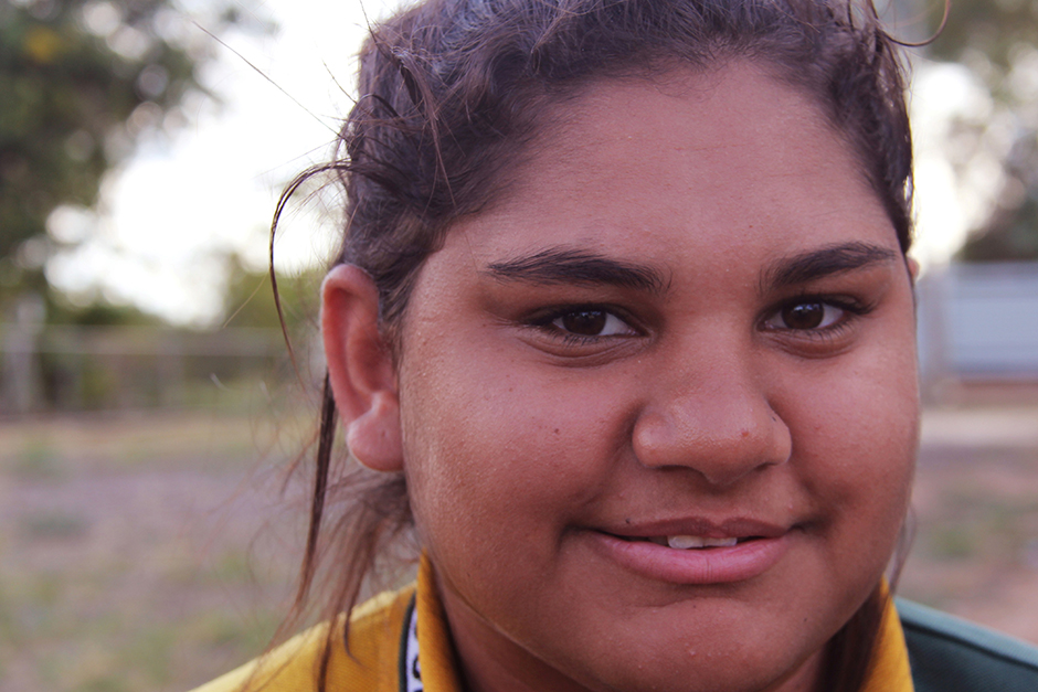 A young Aboriginal woman looks directly at the camera