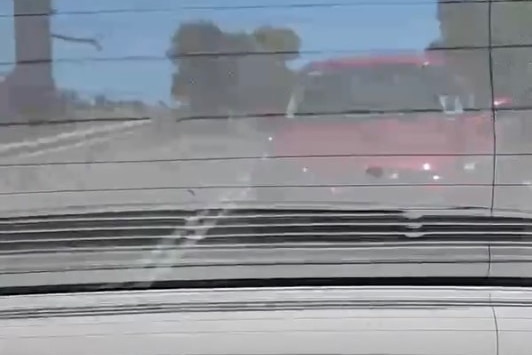 A red car following close behind another car