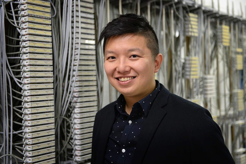 A man standing inside a large computer room