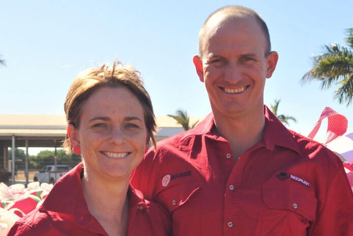 Close up of a man and a woman wearing red shirts smiling at camera