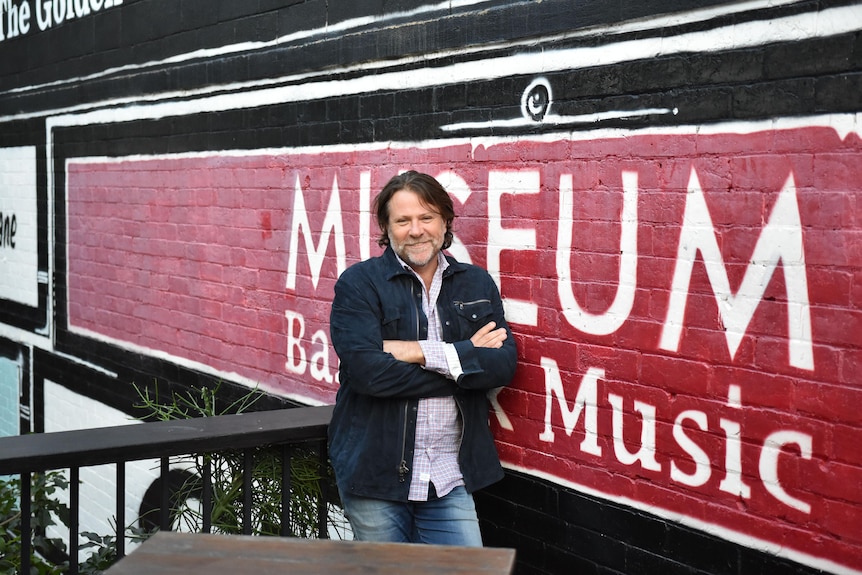 Bass player from Powderfinger John Collins standing outside a music venue in Brisbane.