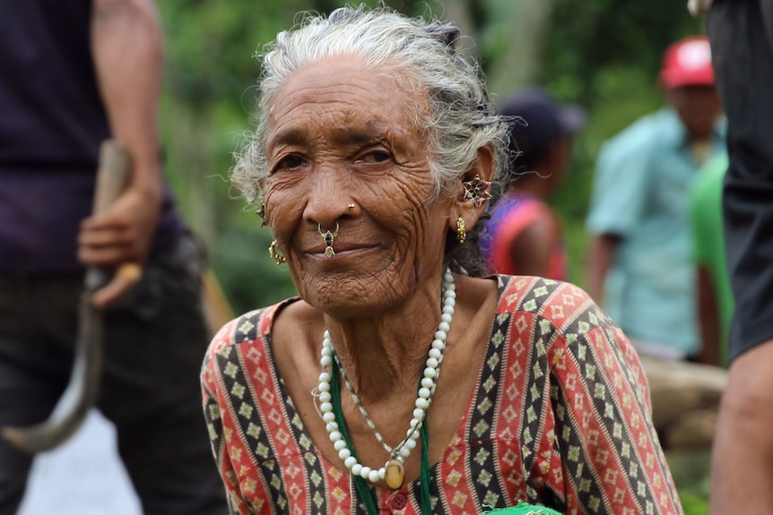 Sita, 70, watches on as local villagers build her a new home