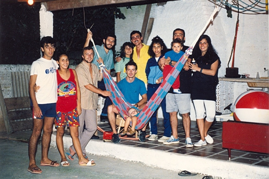 Old photograph of Brazilians around a hammock at a Spiritist church group gathering.