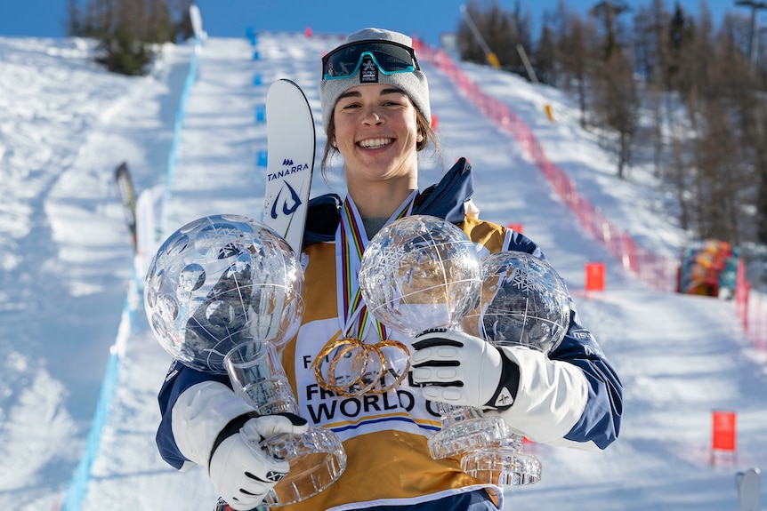 Jakara Anthony holds three crystal globe trophies