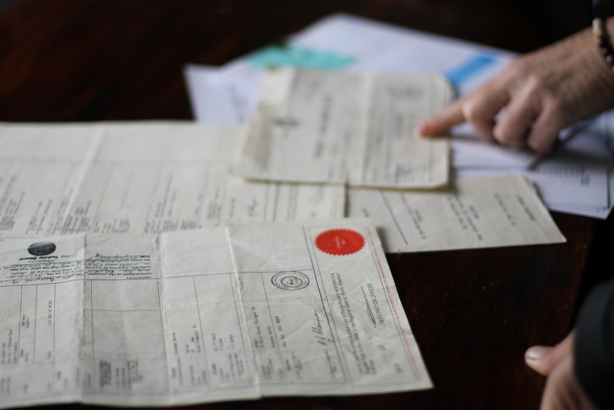 documents including birth certificate and extract on table