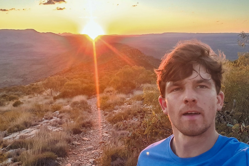 Photo of man in mountainous desert at sunrise
