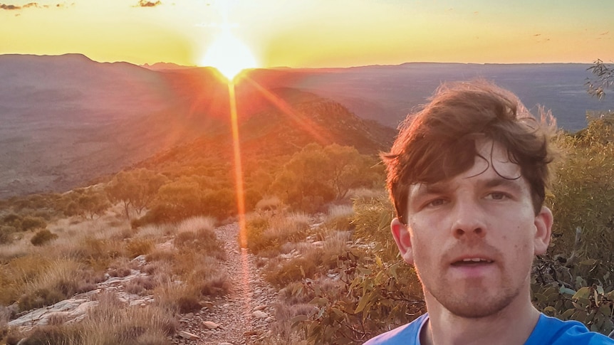 Photo of man in mountainous desert at sunrise