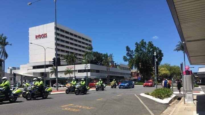 A police motorcade travels through the streets of Cairns.