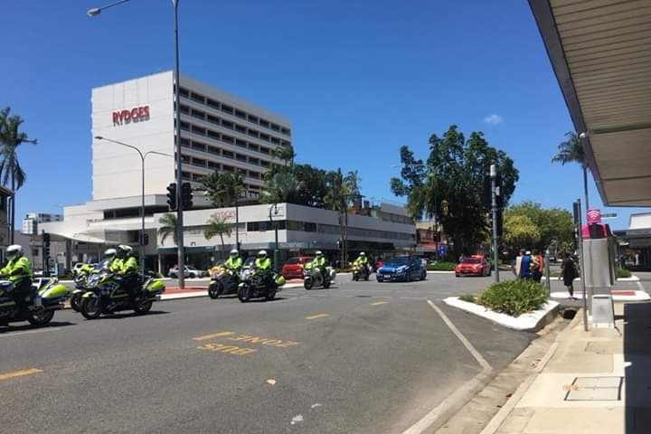 A police motorcade travels through the streets of Cairns.