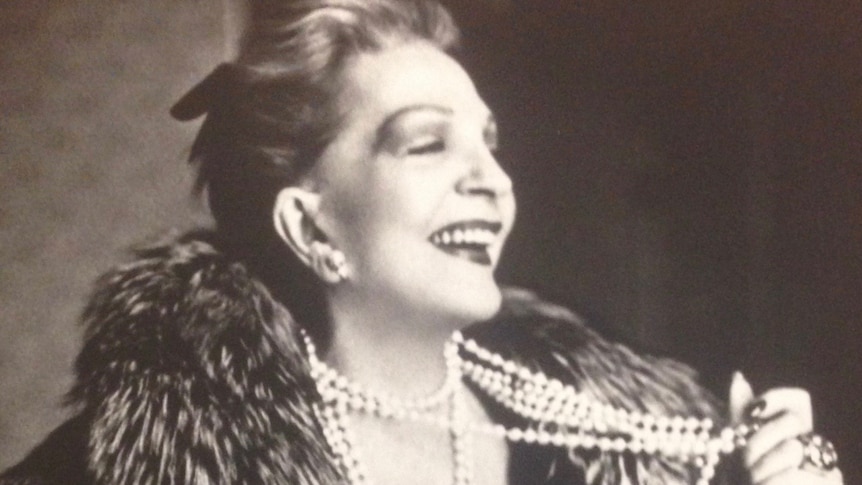 A sepia image of a young Coral Browne wearing furs and pearls laughing gaily