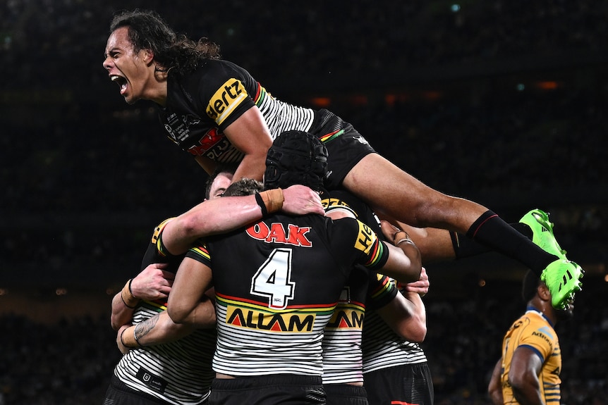 A man screams on the back of men in sport uniforms