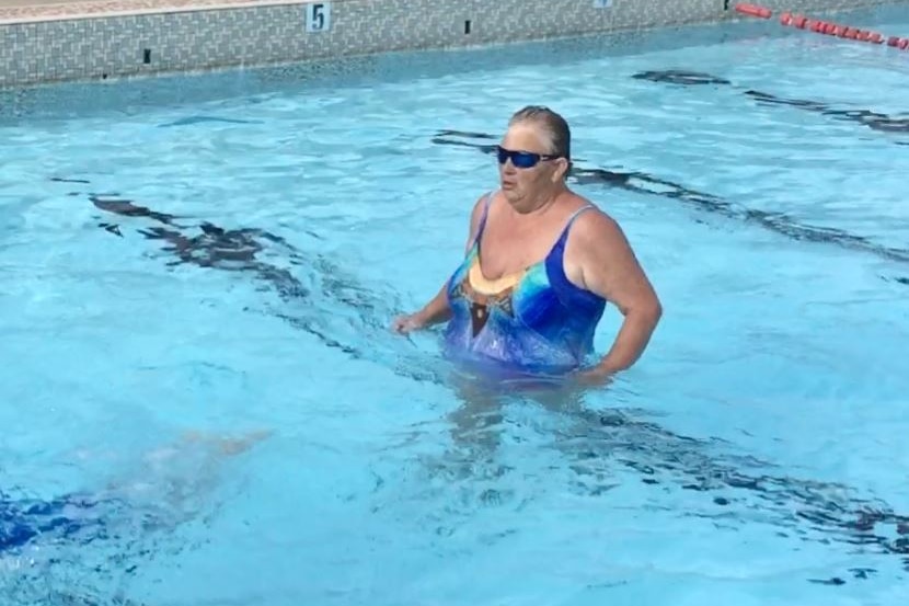 An older woman in a swimming pool.