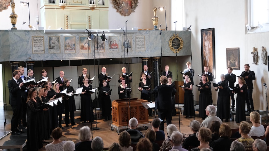 Dressed in concert blacks, in two rows set in a semi-circle, the Swedish Radio Choir singing.