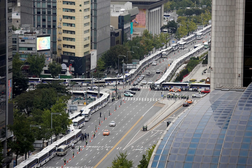 A shot from above showing lines and lines of buses.