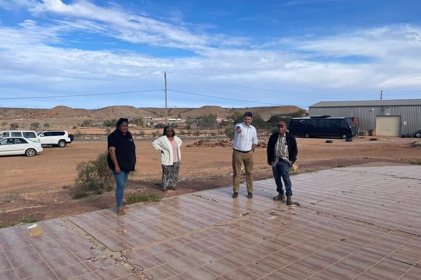 Four people standing in an outback setting