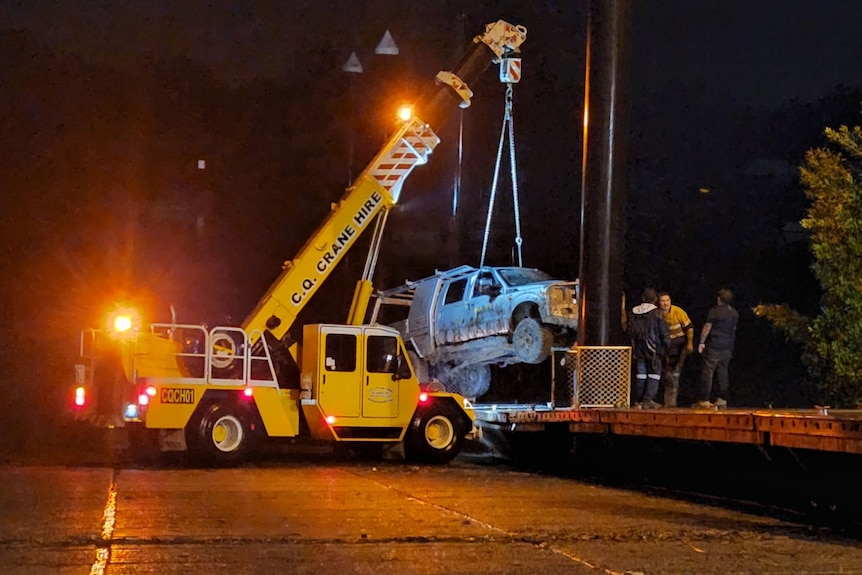 A car being lifted by a crane. 