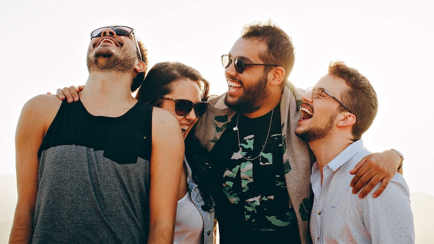 Four young people share a joke