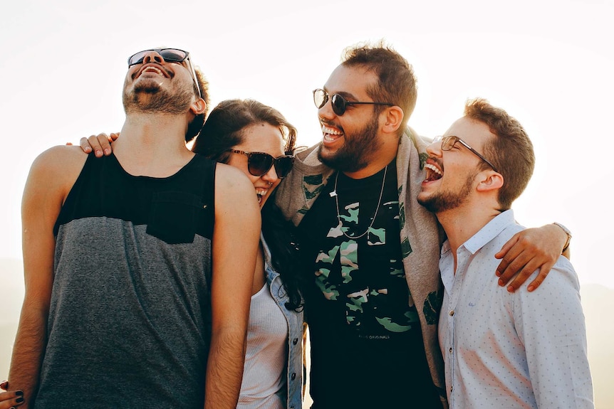 Four young people share a joke