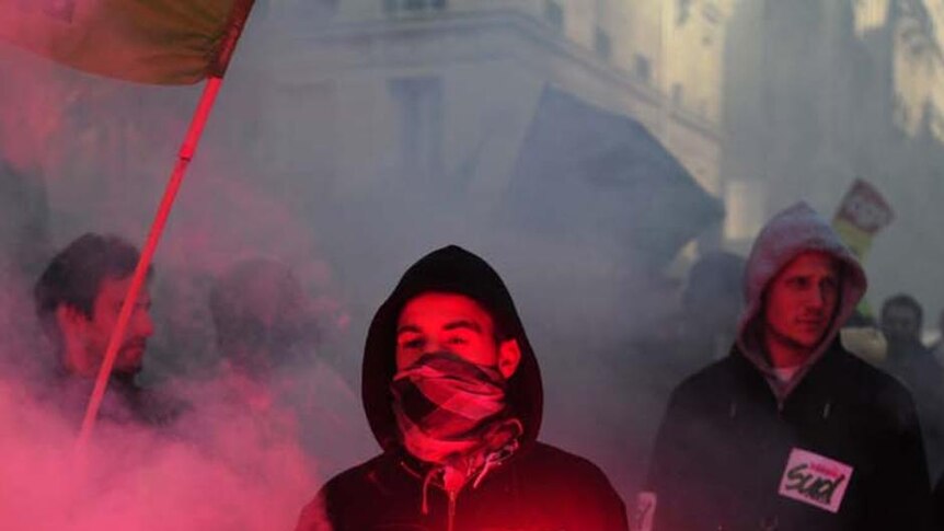 Pension protest: rail workers hold flares in Paris as part of nationwide rallies against pension reform.