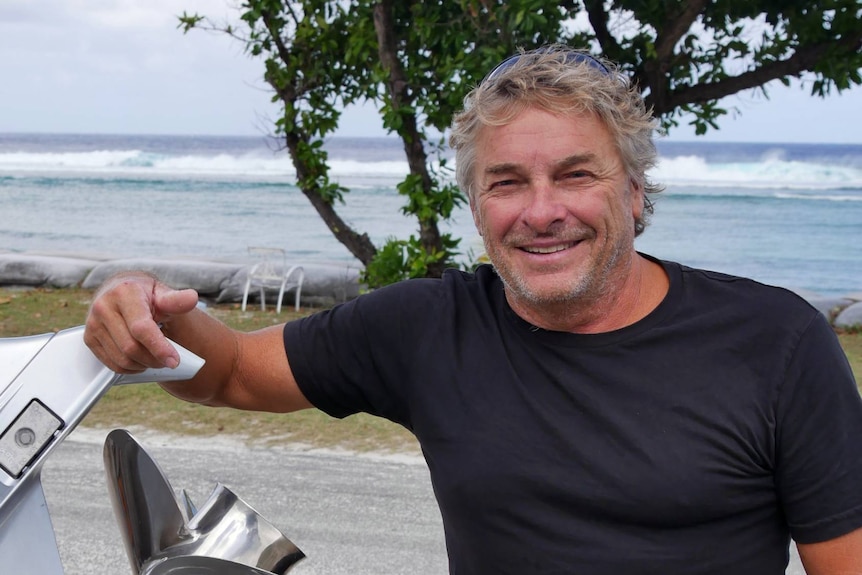 Cocos Island's tour operator Peter McCartney stands by the engine of his tour boat on West Island.
