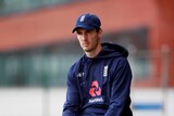 England cricketer Steven Finn wearing a training tracksuit and sitting on a turf rolling machine.