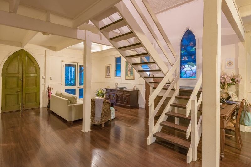 Interior of a home which is a converted church with stained glass windows.