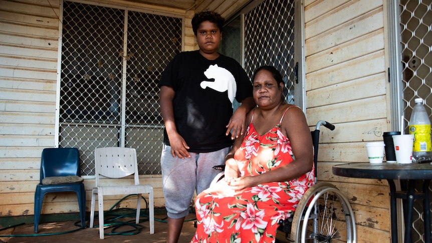 15-year-old Taylen stands next to his mother Cherylene, who uses a wheelchair, at a home in Katherine. 
