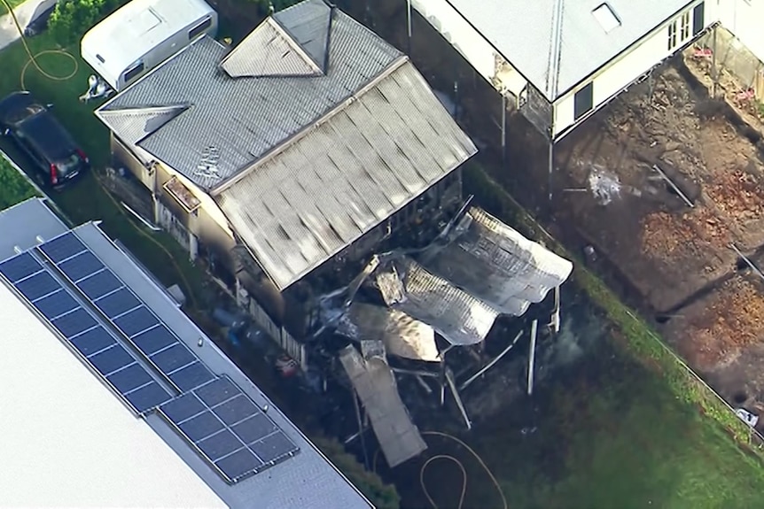 Aerial shot shows burnt out structure at the rear of the home, with collapsed roof and walls.