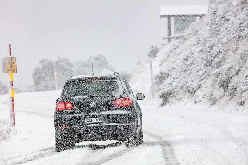 A car drove down a snow-covered street at Mount Hotham.