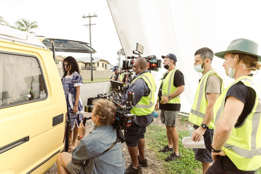 A group of crew members on set filming. 