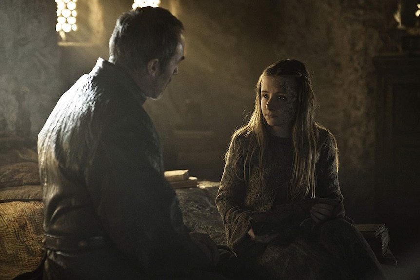 A man talks to a girl in a room in a scene from a fantasy tv show