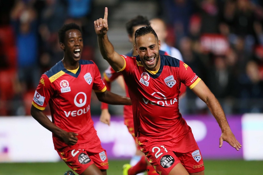Adelaide's Tarek Elrich celebrates with team-mates after his goal against Melbourne City.
