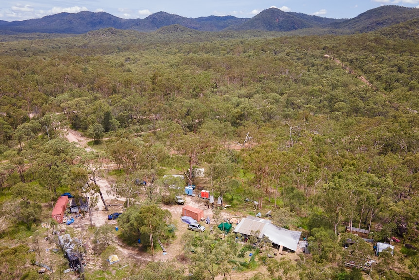 small bush camp amongst trees at the feet of mountain range