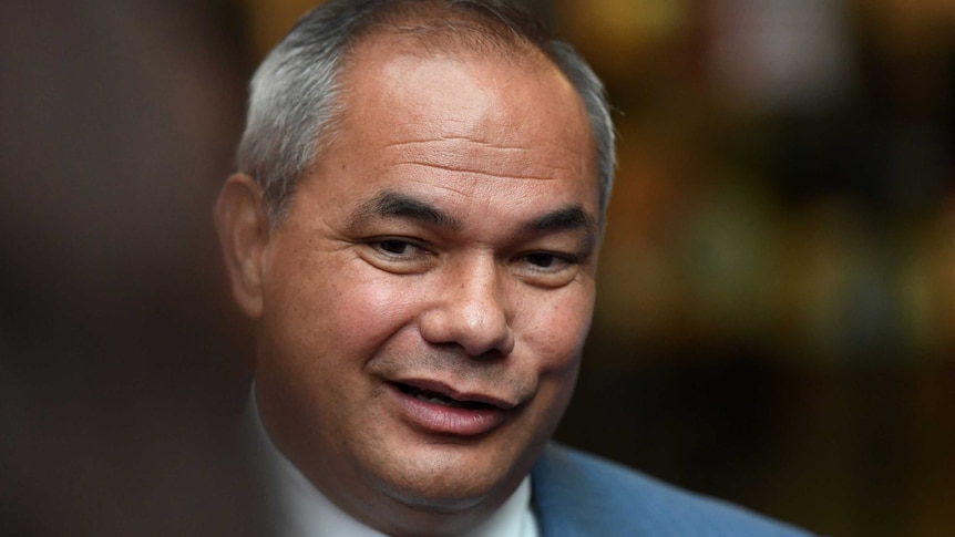 A man with grey, receding hair, wearing a suit.