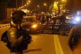 An Israeli policeman stands near the car of the Palestinian shooter.