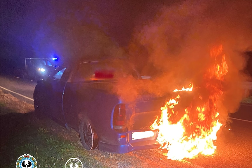 A blue ute with the rear on fire