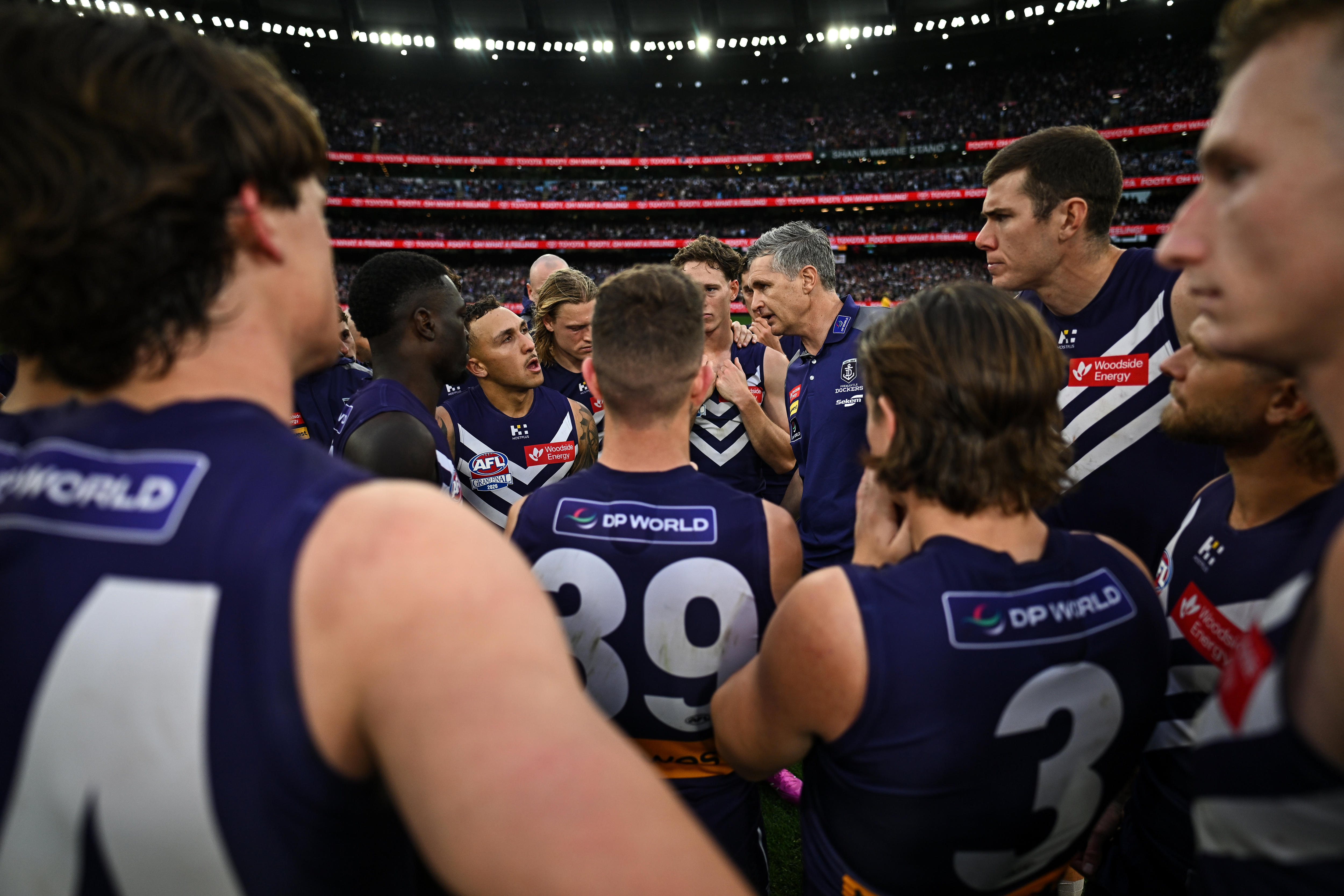 Justin Longmuir speaks in a huddle of Fremantle players
