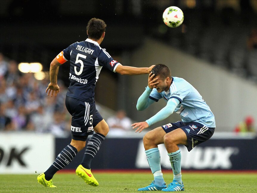 Mark Milligan of Victory and Terry Antonis of Sydney collide during the round 11 A-League match between Melbourne Victory and Sydney FC