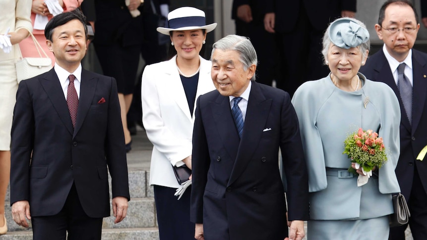 Japanese Emperor Akihito and Crown Prince Naruhito wave from a balcony