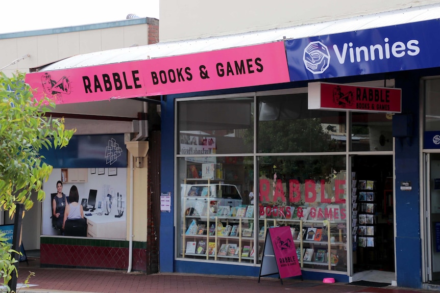 The storefront from the street shows books in the window and an A-frame out front.