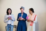 Three women from the Geek Girl Academy look at their phones.