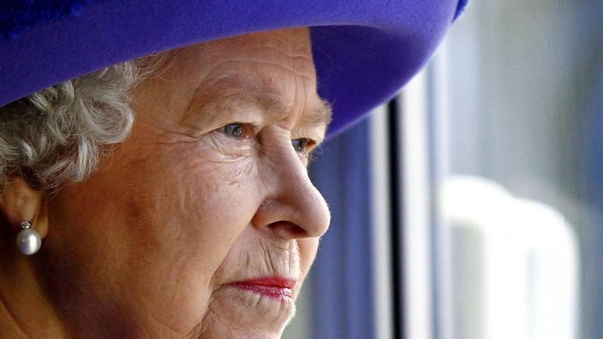 Britain's Queen Elizabeth II looks out from a window at the underwater stage at the Pinewood Studios