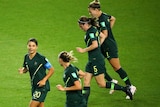 Four Matildas players job on green grass