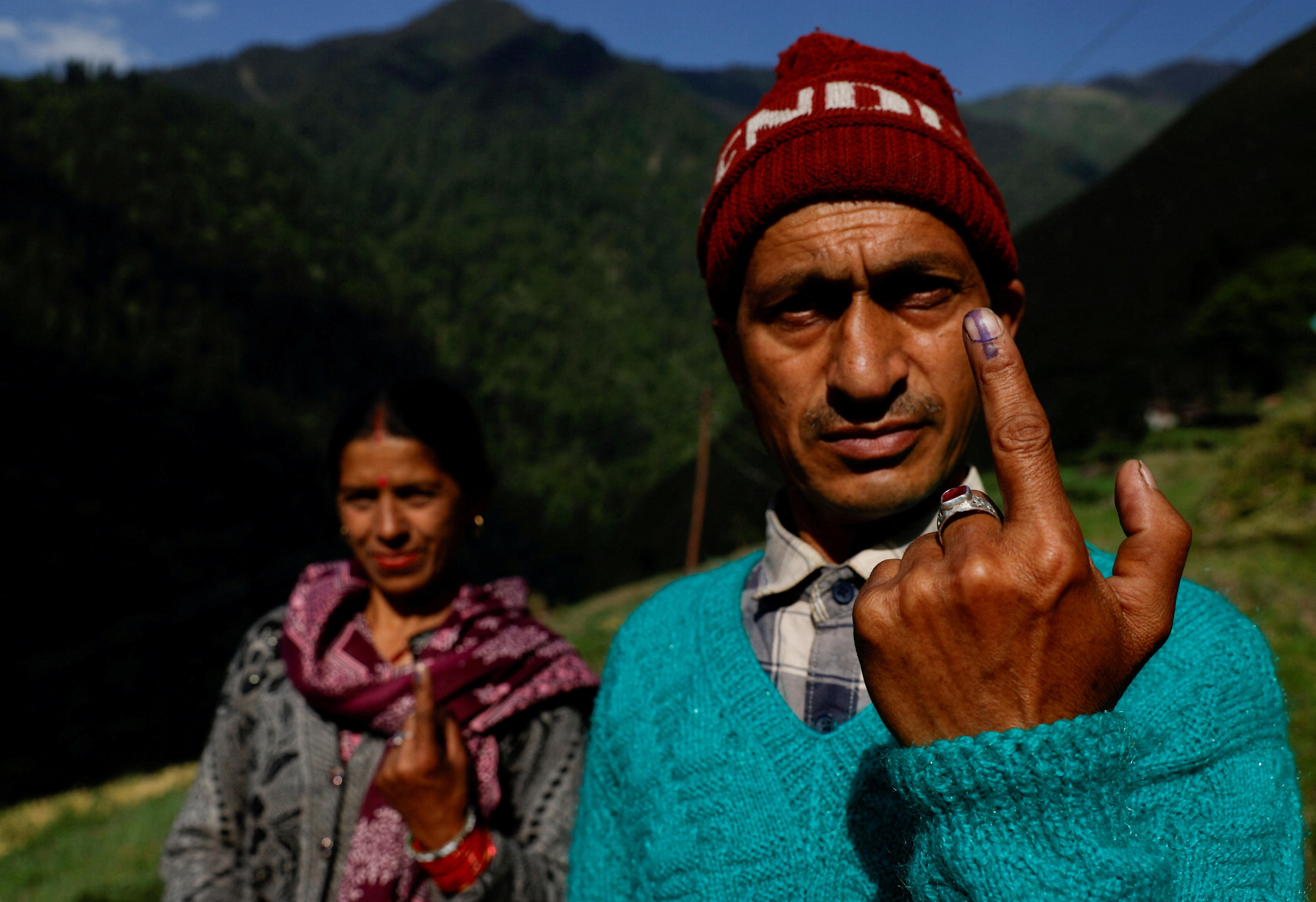 A man holds up his ink-stained fingers 