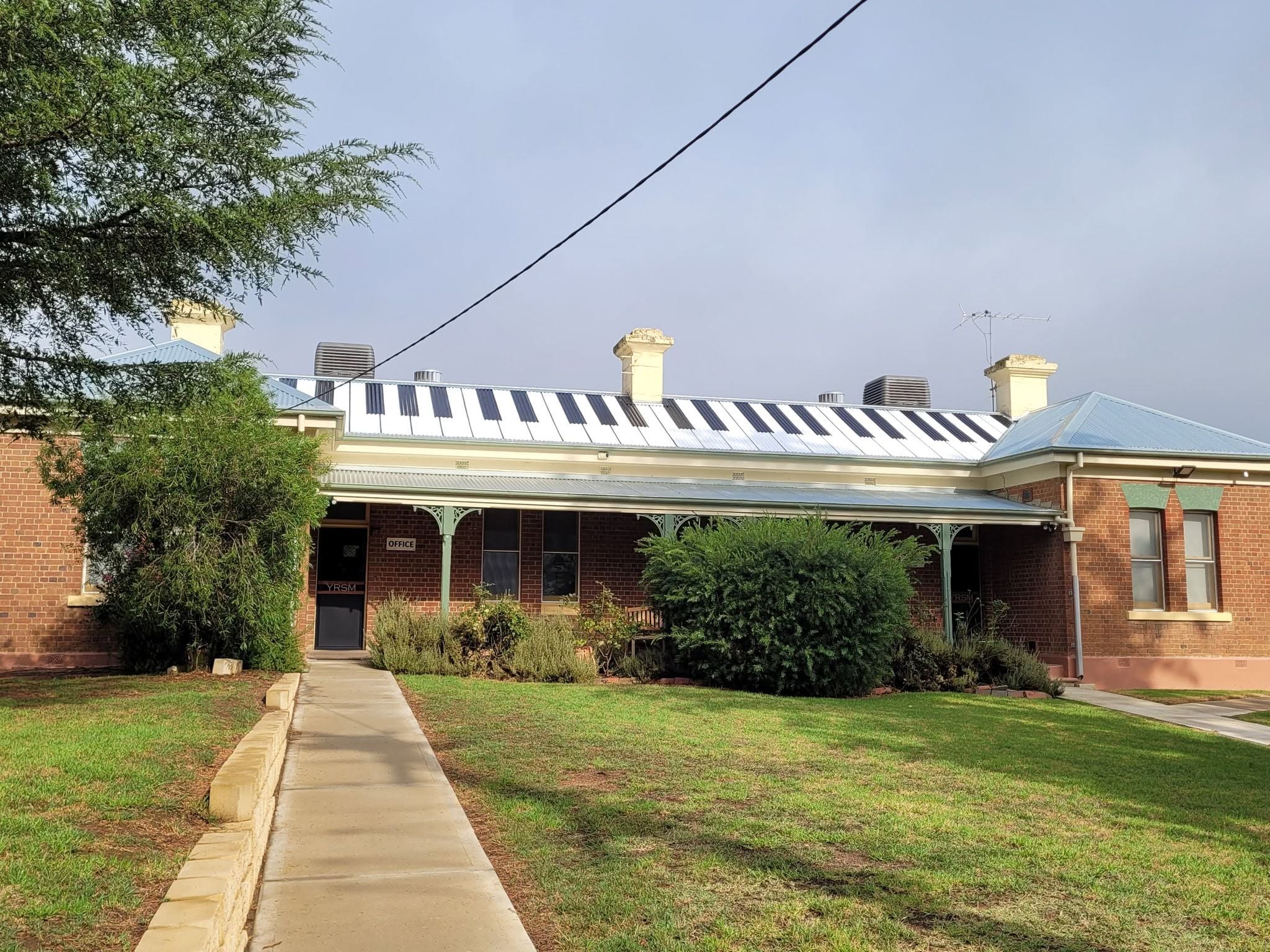A building with a roof that is painted with stripes to look like the keys of a piano