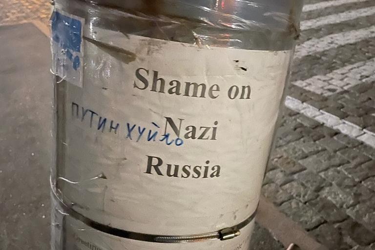 A printed sheet saying 'Shame on Nazi Russia' taped to a pole