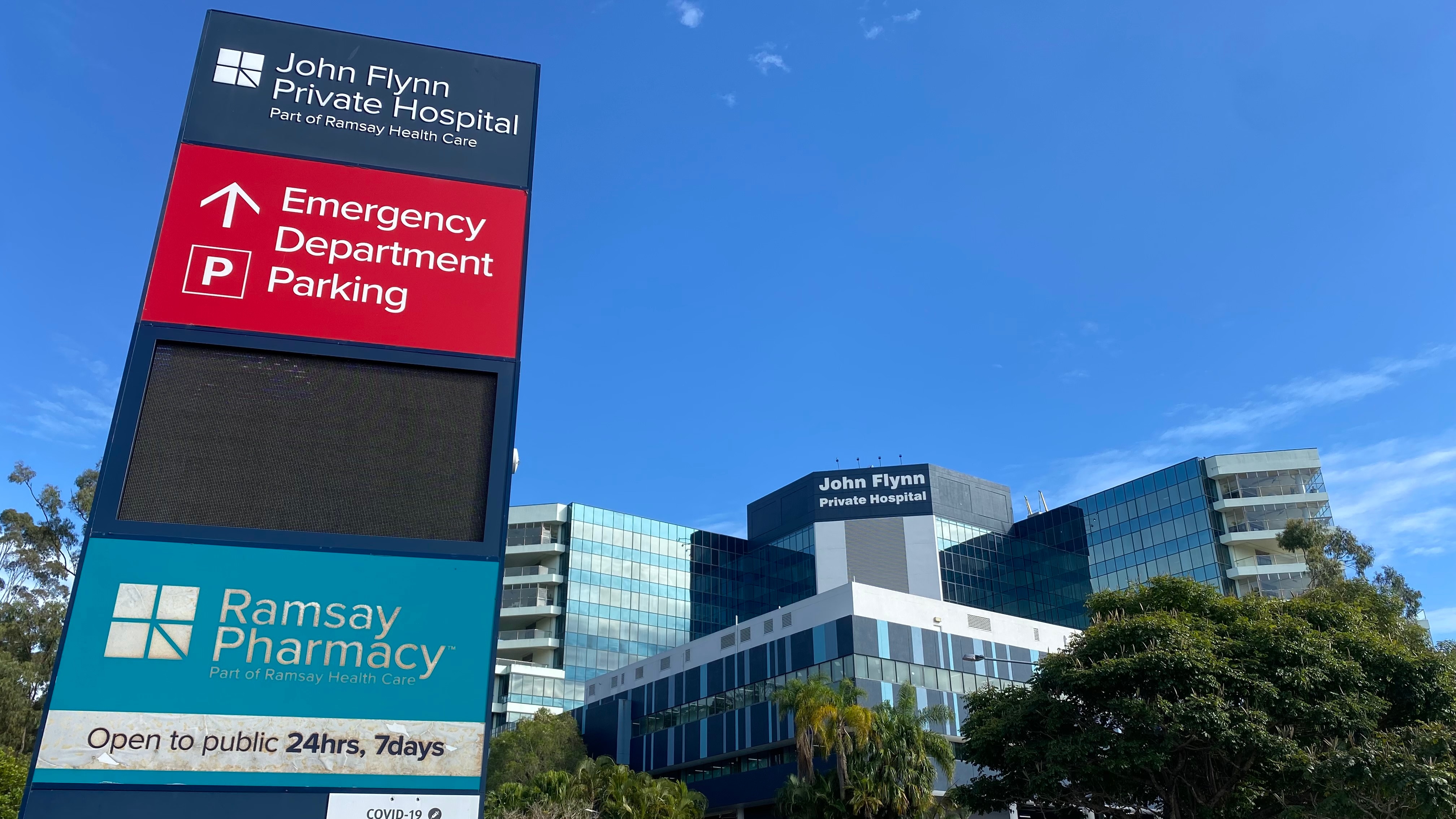 signage outside hospital with blue sky